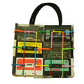 Handbag made from recycled cassette tapes with colorful straps on a white background