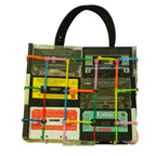 Handbag made from recycled cassette tapes with colorful straps on a white background