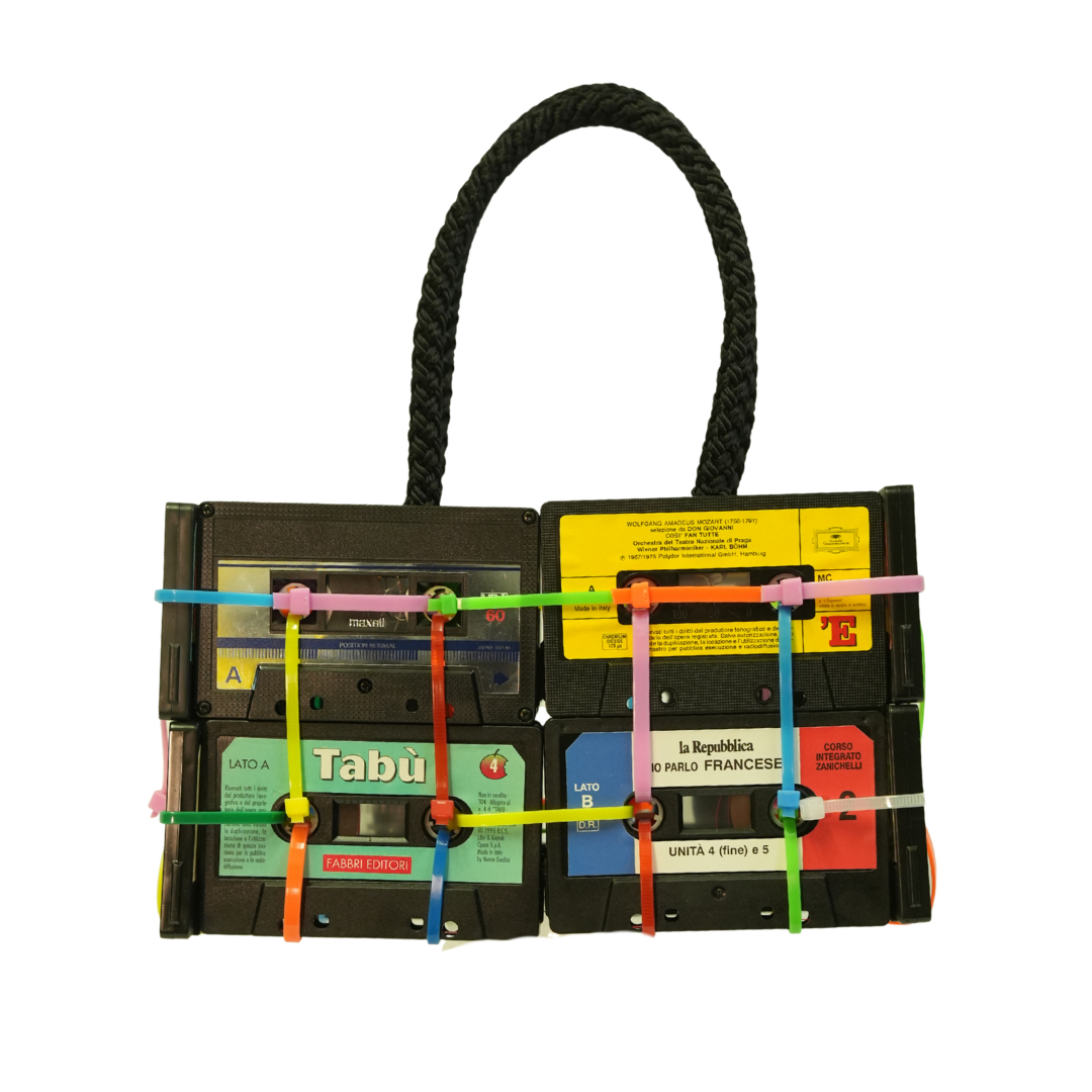 Handbag made from recycled cassette tapes with colorful straps on a white background