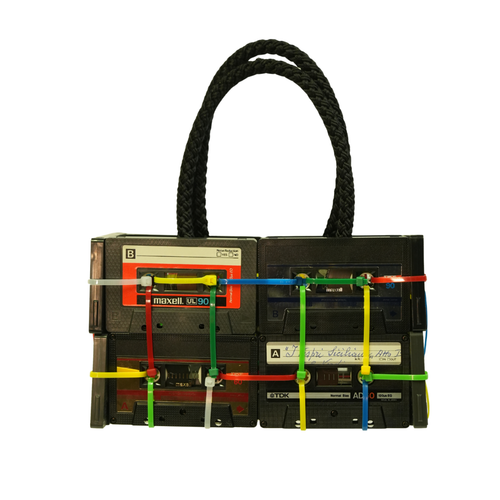 Handbag made from recycled cassette tapes on a white background