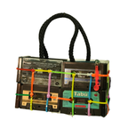 Handbag made from recycled cassette tapes with colorful ribbons on a white background