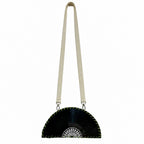 A black vinyl record half-moon shoulder bag with a cream-colored fabric strap and a white geometric pattern on the center, shown against a plain white background.