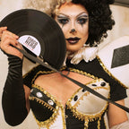 Person in elaborate costume holding a record with 'Circo Nero' branding