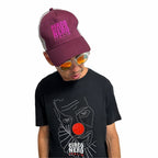 Person wearing a maroon 'Circo Nero Italia' cap and black t-shirt with graphic design on a white background
