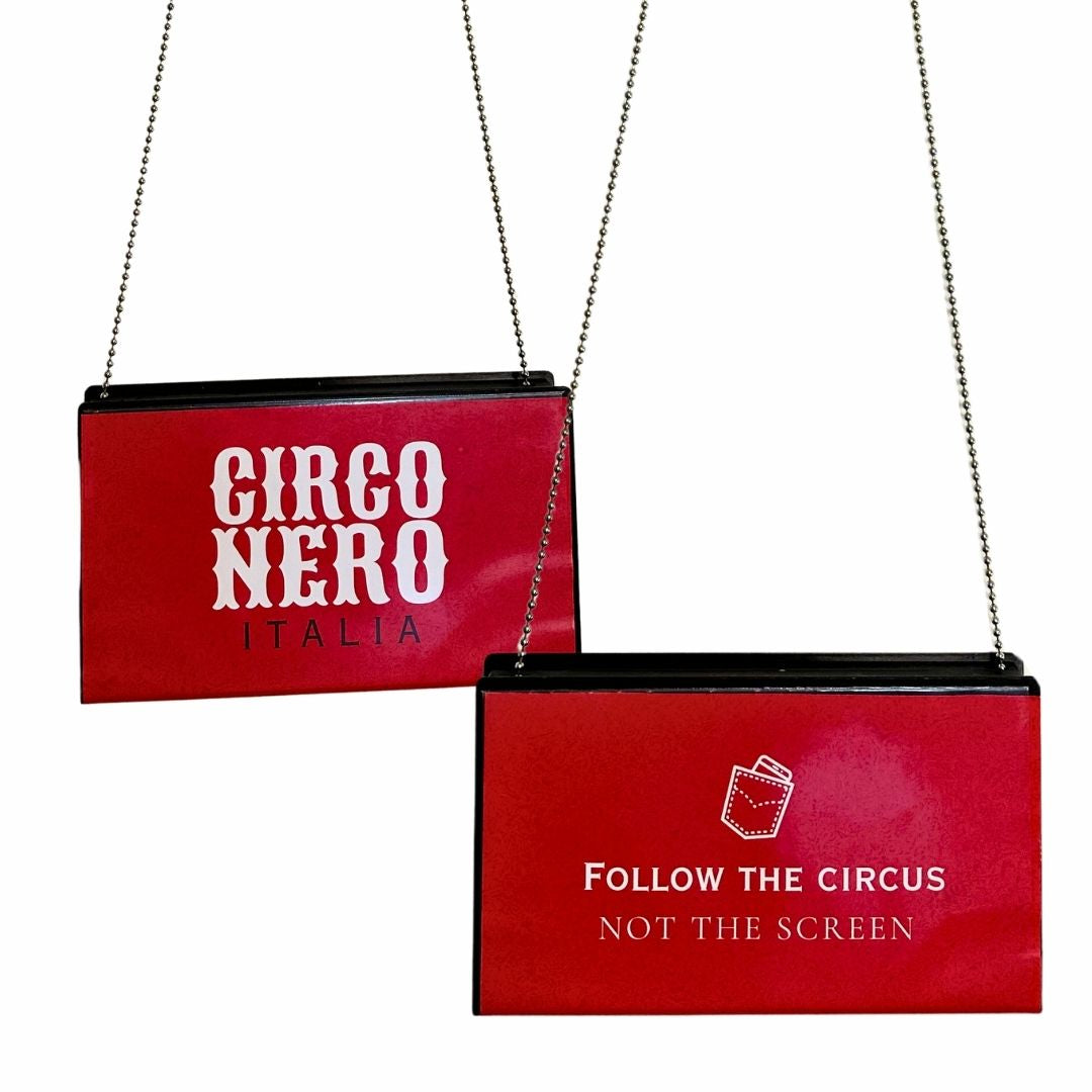 Red clutch bags with 'Girco Nero Italia' and 'Follow the Circus Not the Screen' text on a white background