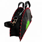 A black vinyl record shaped shoulder bag with red contrast stitching, black leather handles, a black fabric body, and a gold-tone clasp, shown on a plain white background.