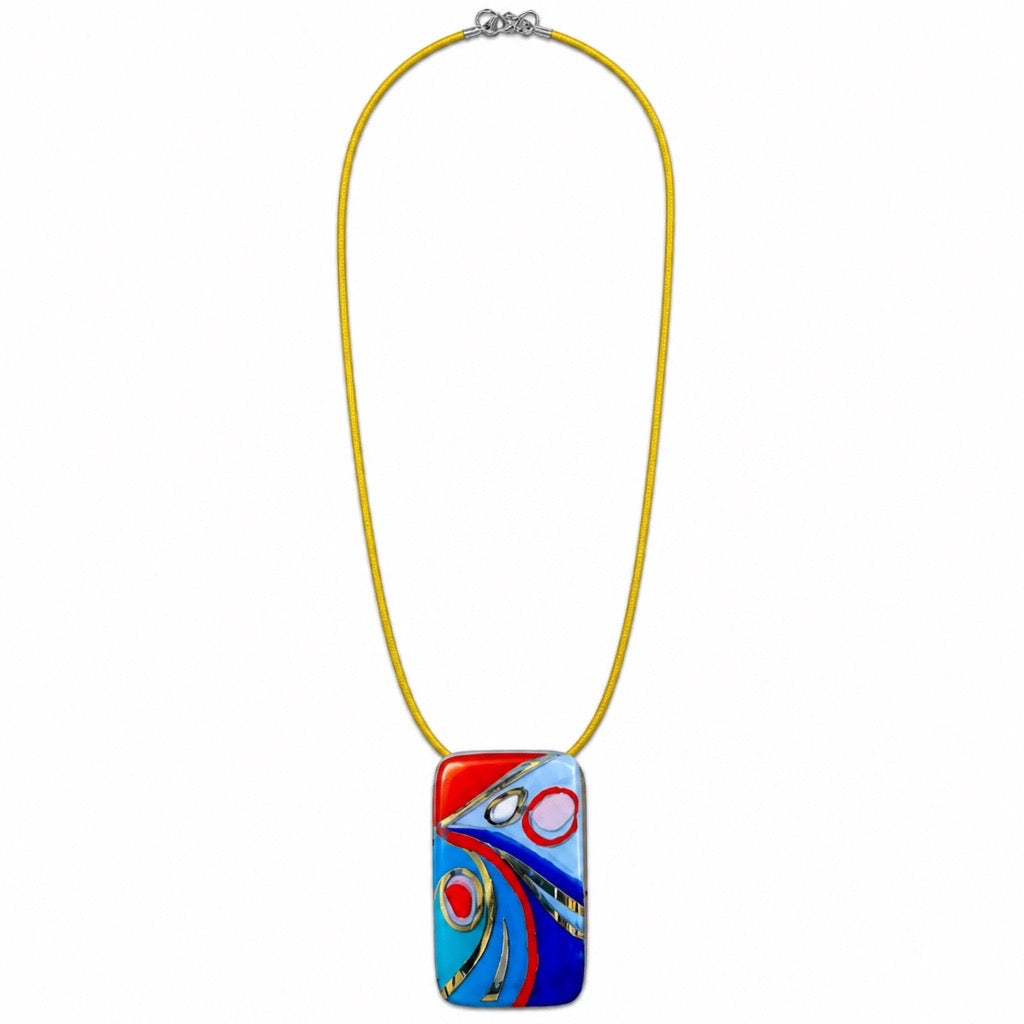 A colorful rectangular glass pendant necklace with an abstract swirl design in red, blue, and white, suspended on a bright yellow cord with a silver clasp, shown against a plain white background. Silvia Tolomei best handmade jewelry in Tuscany. Tuscany jewelry. Tuscan jewelry. Populonia best store to visit. Things to do in populonia. 
