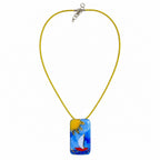 A yellow cord necklace with a rectangular glass pendant featuring a colorful sailboat scene in blue, yellow, white, and red, displayed on a clean white background. Silvia Tolomei best handmade jewelry in Tuscany. Tuscany jewelry. Tuscan jewelry. Populonia best store to visit. Things to do in populonia. 