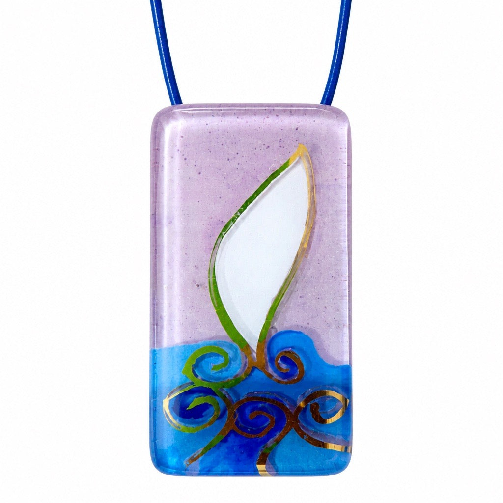 A rectangular glass pendant necklace featuring a stylized flame design with a white center, green and gold outlines, and a blue base, suspended on a blue cord against a white background. Silvia Tolomei best handmade jewelry in Tuscany. Tuscany jewelry. Tuscan jewelry. Populonia best store to visit. Things to do in populonia. 