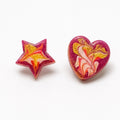 A pair of handmade resin stud earrings on a white background, featuring one star-shaped earring and one heart-shaped earring, both with a marbled swirl pattern of pink, yellow, orange, and white. Silvia Tolomei best handmade jewelry in Tuscany. Tuscany jewelry. Tuscan jewelry. Populonia best store to visit. Things to do in populonia. 