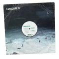 A vinyl record sleeve for Cynosure's 'Wave Scanner' LP, featuring a dark, moody ocean scene with surfers on the cover. The white center label of the vinyl is visible, and the record is photographed flat against a white background.