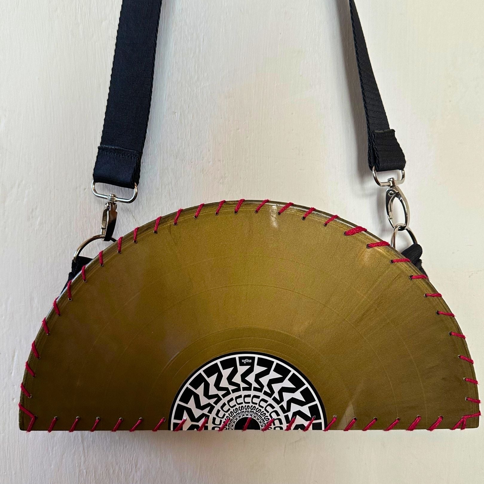 Yellow circular saw blade bag with black strap on a white background. francesca farfa musek label sorry im not a deejay vinyl purse