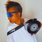Person holding a unique bag with a geometric design, wearing colorful sunglasses. musek black round bag